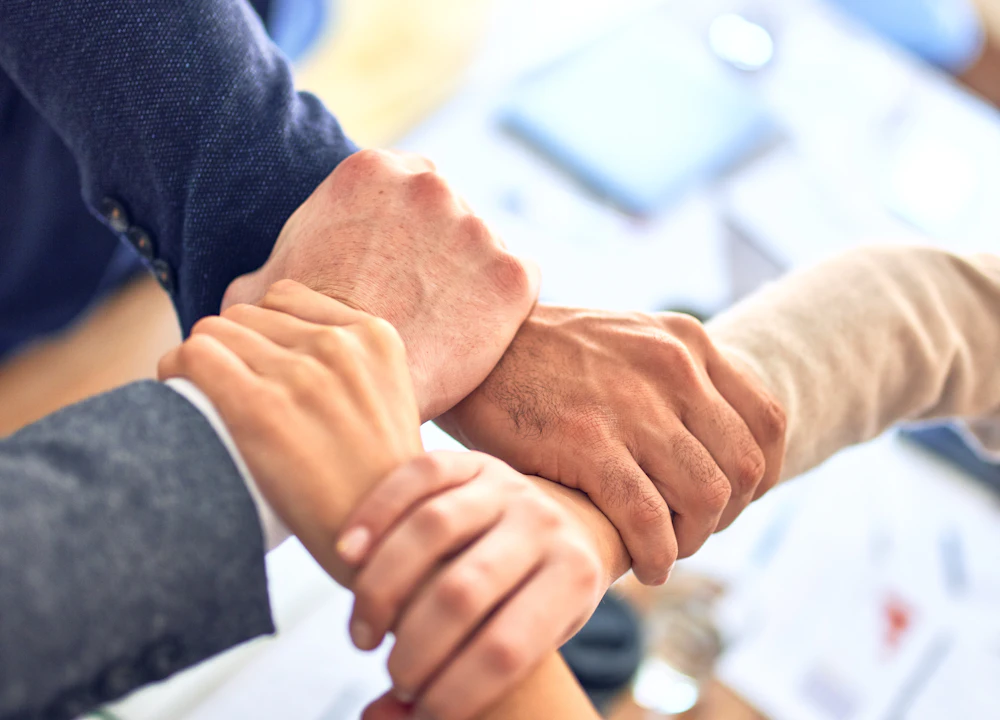 Colleagues joining hands as a team