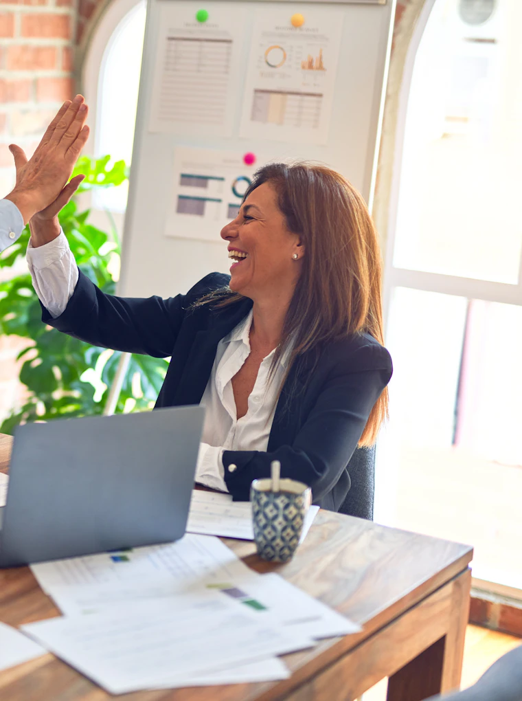 Two colleagues celebrating a result at their desk